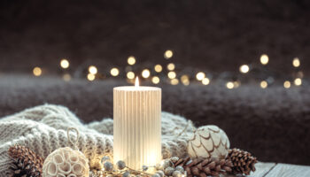 Cozy Christmas composition with a candle on a blurred background.