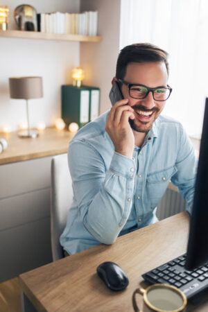 Smiling,Handsome,Freelancer,Working,Remotely,From,Home.,He,Is,Speaking