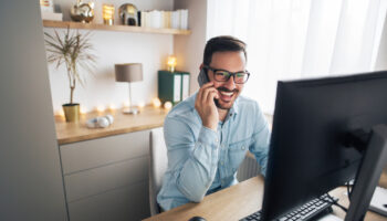 Smiling,Handsome,Freelancer,Working,Remotely,From,Home.,He,Is,Speaking