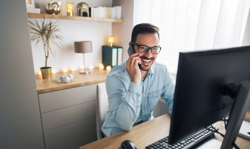 Smiling,Handsome,Freelancer,Working,Remotely,From,Home.,He,Is,Speaking