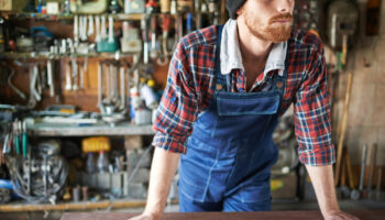 Portrait,Of,Unrecognizable,Bearded,Male,Leaning,On,Table,With,Wrenches